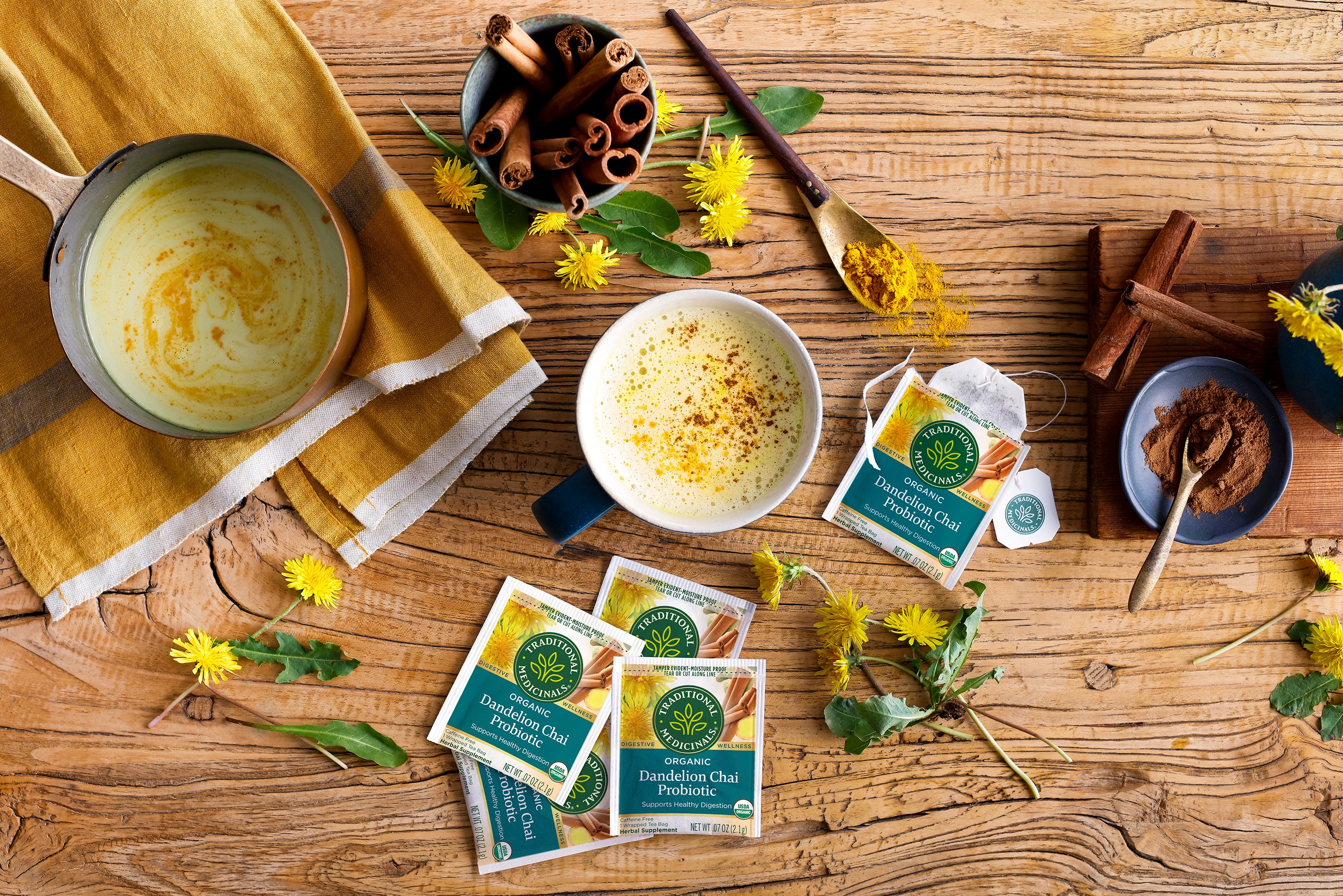 Dandelion Chai Tea box overhead on table with dandelions and cinnamon