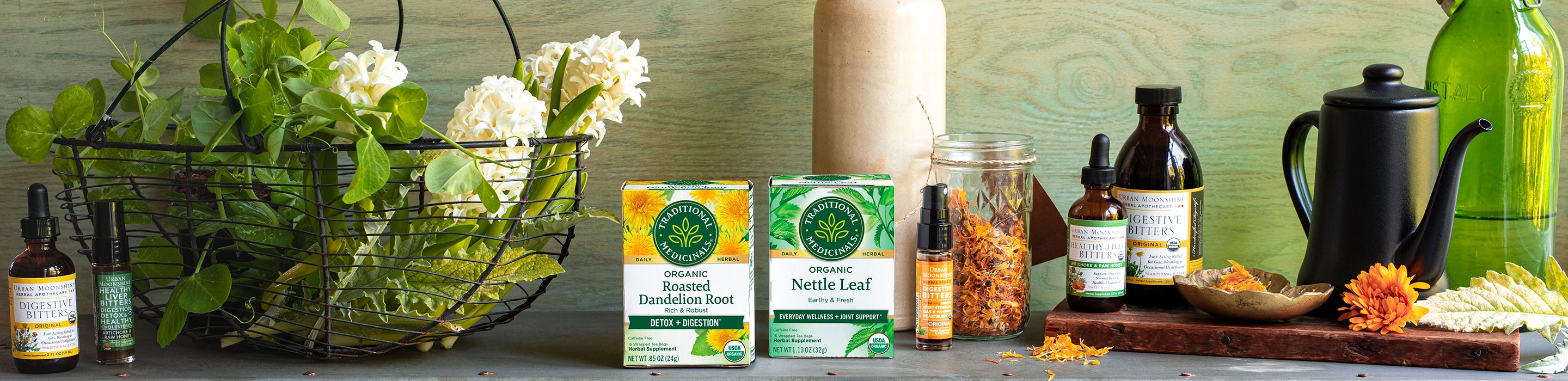 Two Traditional Medicinals tea boxes along with tincture bottles and flowers on shelf