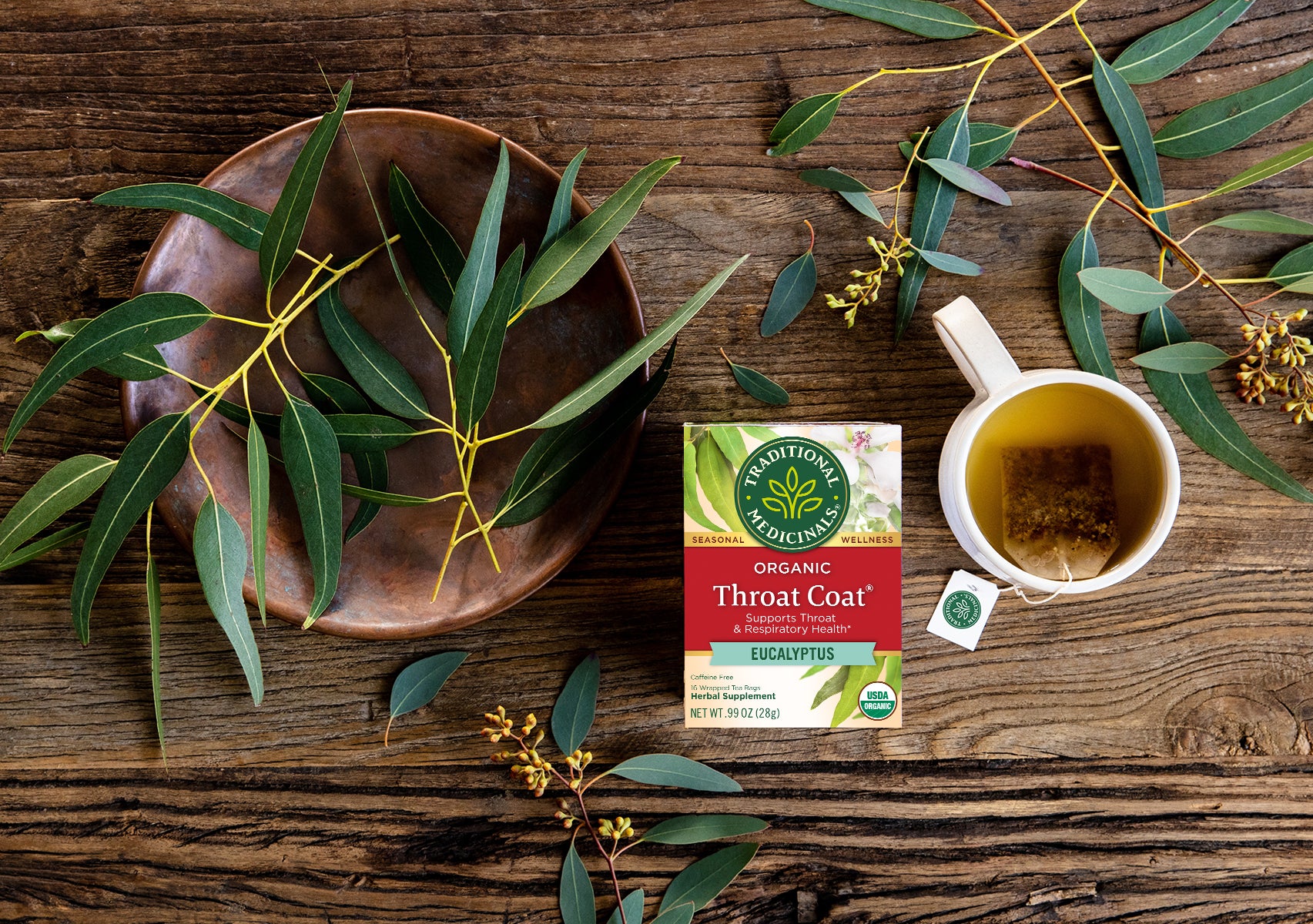 Throat Coat Eucalyptus next to fresh herbs and steeping tea