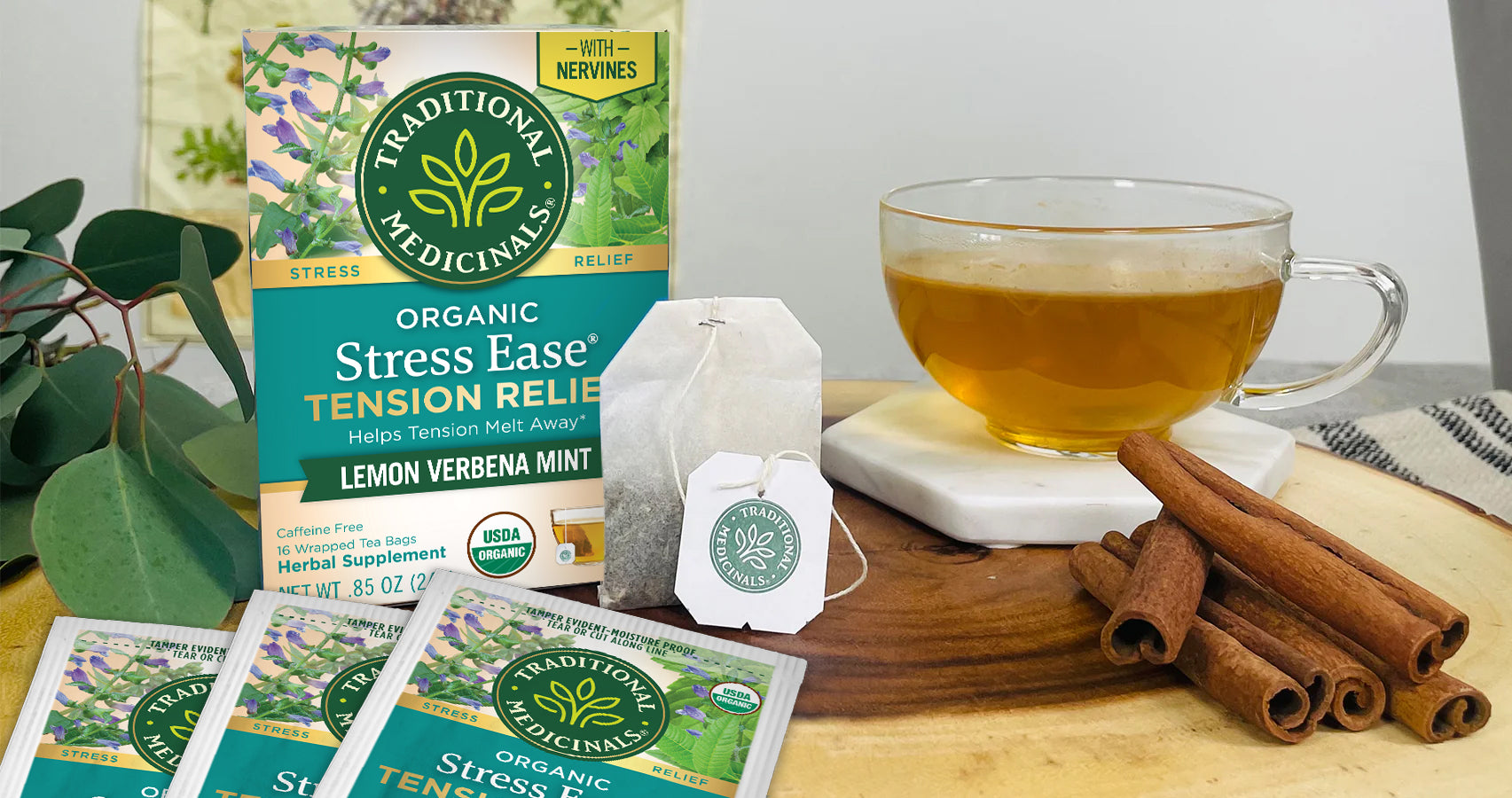 Stress Ease Tension Relief Tea carton, bagged tea, cinnamon and tea cup on table