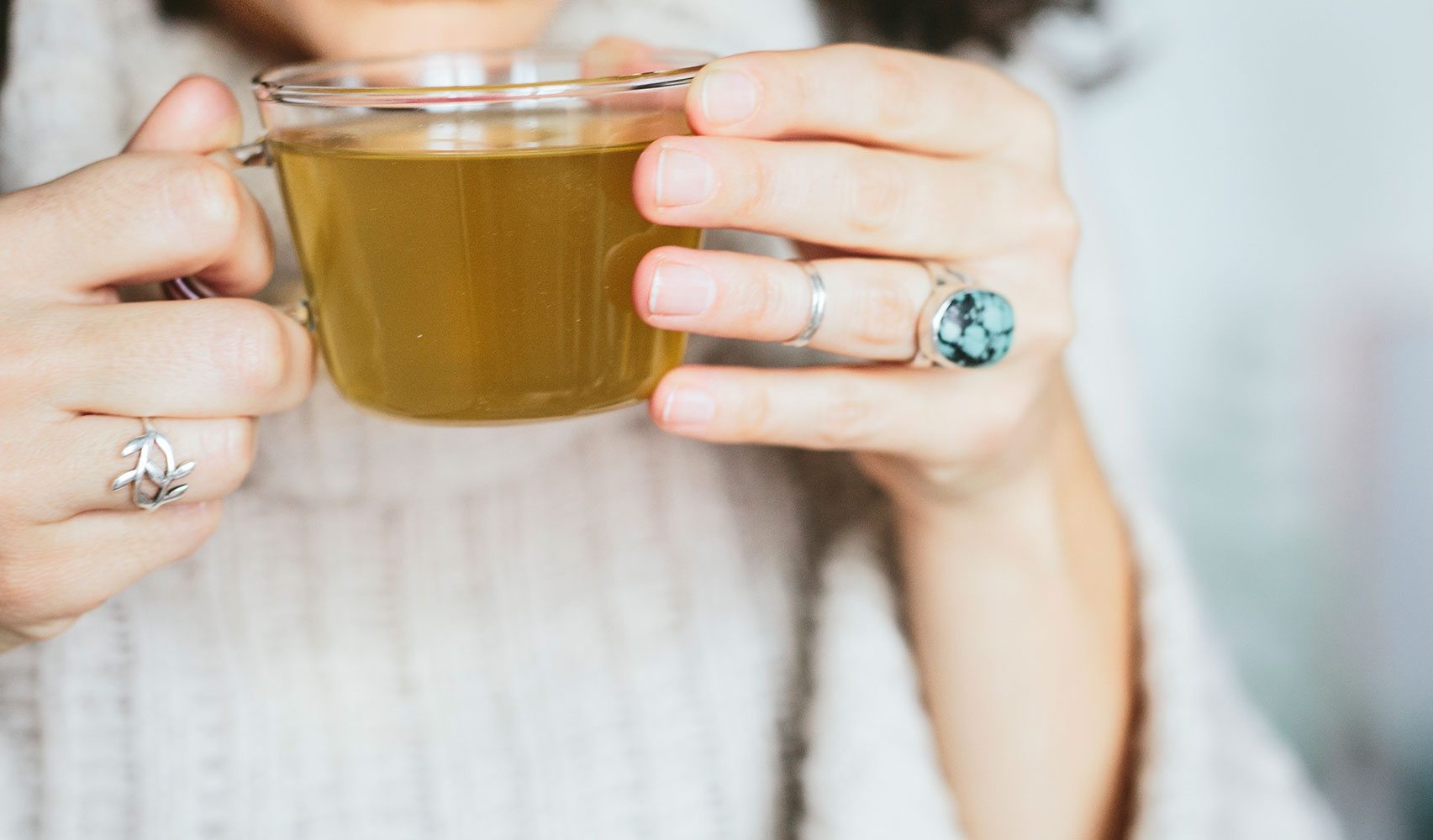 hands holding glass tea cup